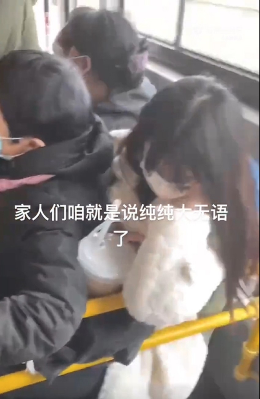 女子手上拿著奶茶，只能盡力不讓奶茶被大媽擠壓到。