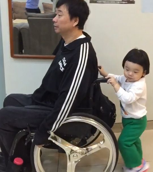 孩子幫姜元來推輪椅