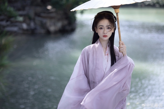 吳謹言撐著油紙傘靜靜矗立,表情淒楚。