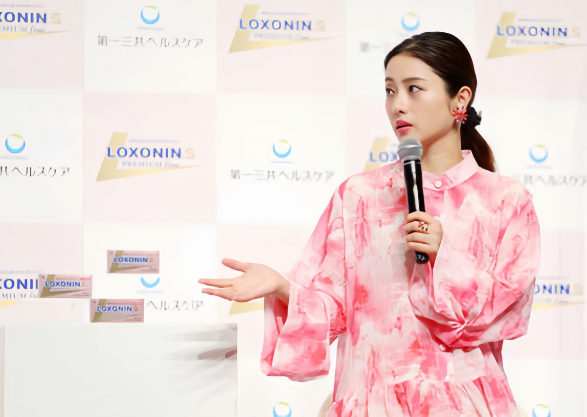 石原，穿著粉白色相間的長裙走上舞台。