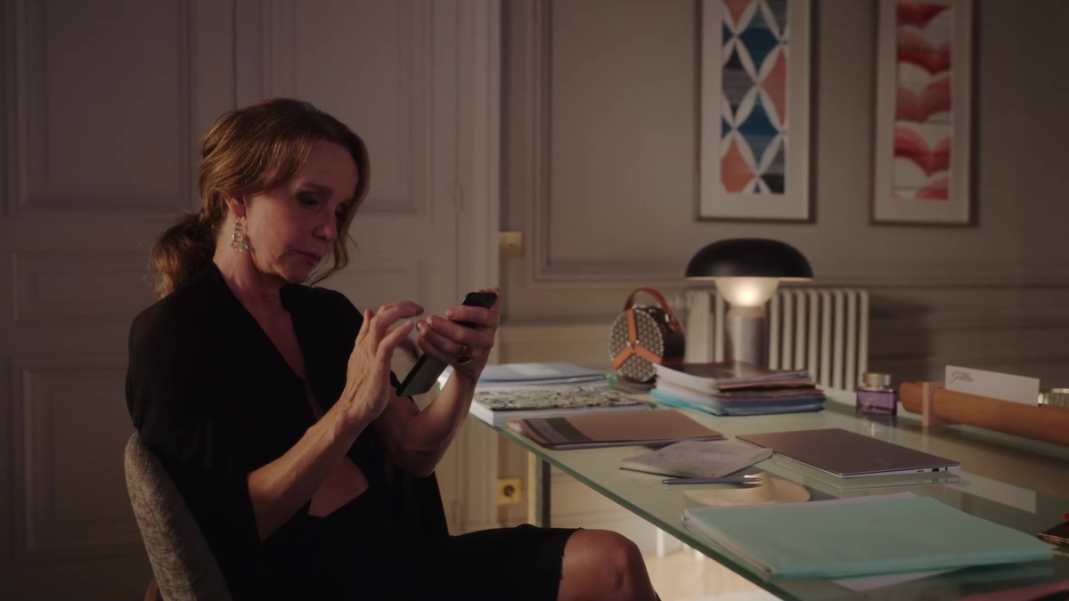 Emily in Paris - 第三季第8集中Sylvie穿著俐落性感的黑色洋裝搭配MOYNAT重新複刻1960並微型化的Wheel手提包。