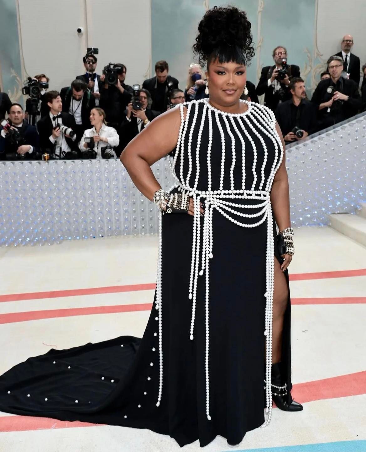 Lizzo 穿上了 Chanel 一件帶有玻璃珍珠背帶的訂製黑色真絲縐紗連衣裙，靈感來源於 Chanel 1991 成衣系列。