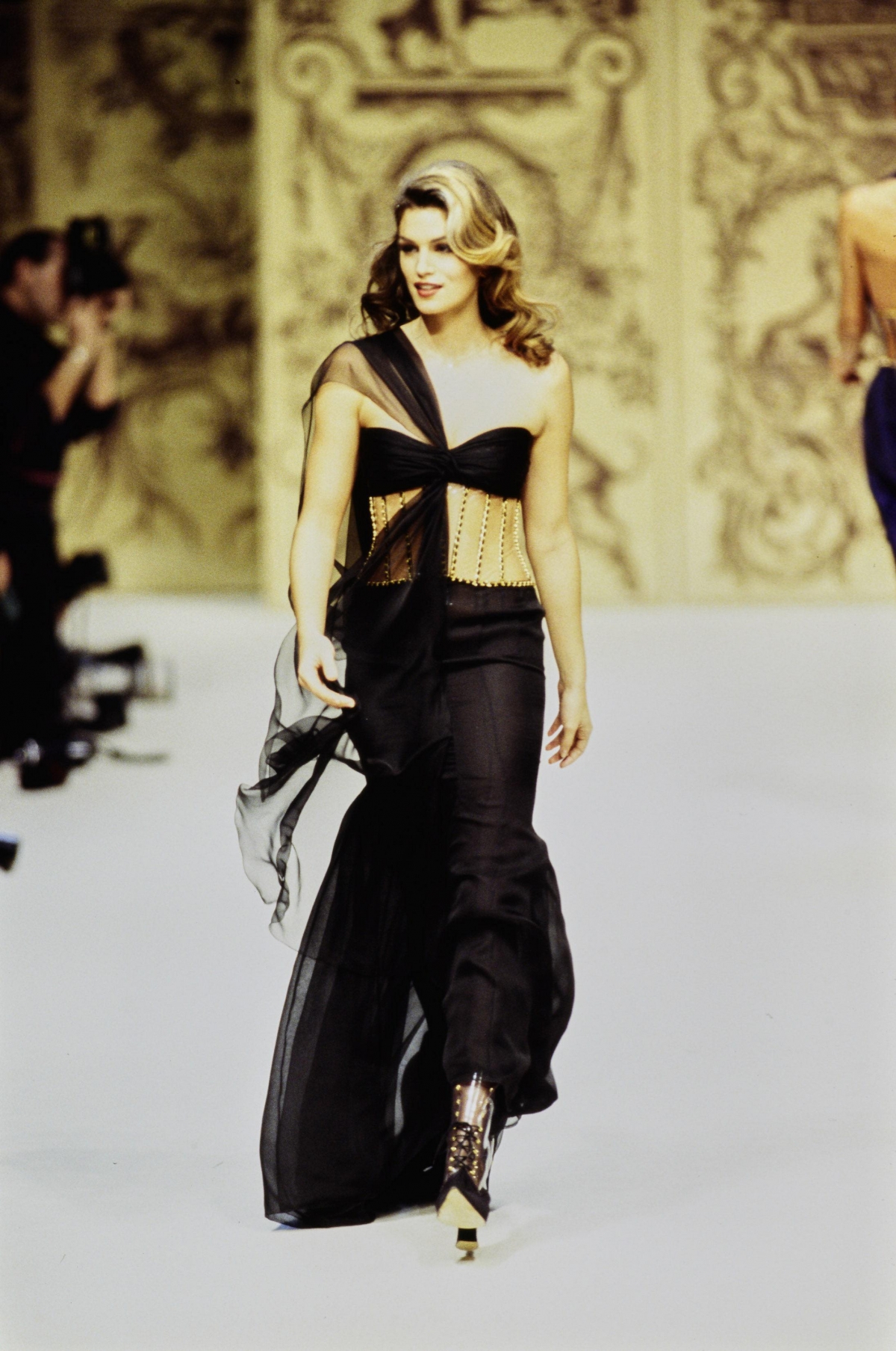 瑪格羅比穿上 Chanel 1993 高訂系列，由當年Karl Lagerfeld 繆斯女神之一 Cindy Crawford 穿上的黑色鏤空金邊絲綢禮服。