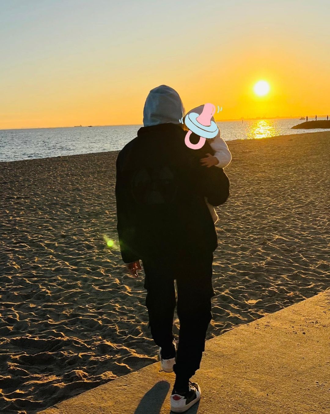 周杰倫抱著孩子在海灘，預告：「爸爸等一下要去開演唱會了！」。