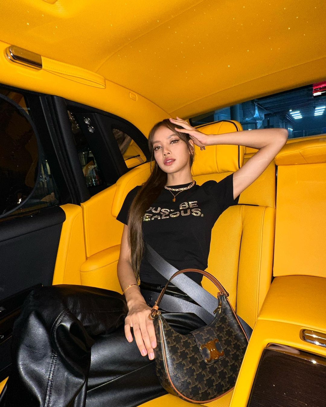 LISA以一身酷帥俐落的黑色勁裝搭配CELINE AVA TRIOMPHE標誌印花小牛皮手袋