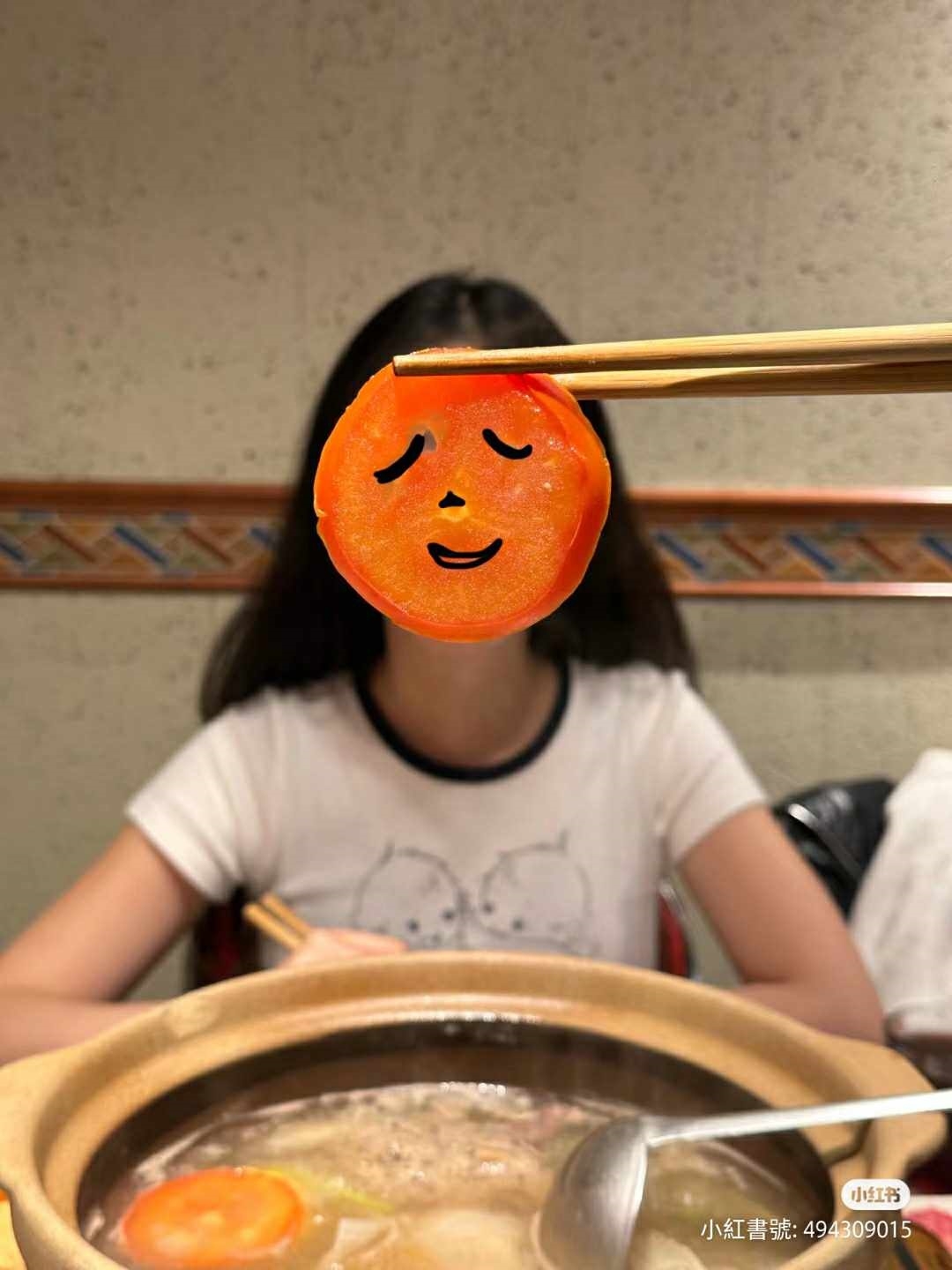 吃火鍋隨手拿起一片食材來擋臉，畫上小表情俏皮又可愛