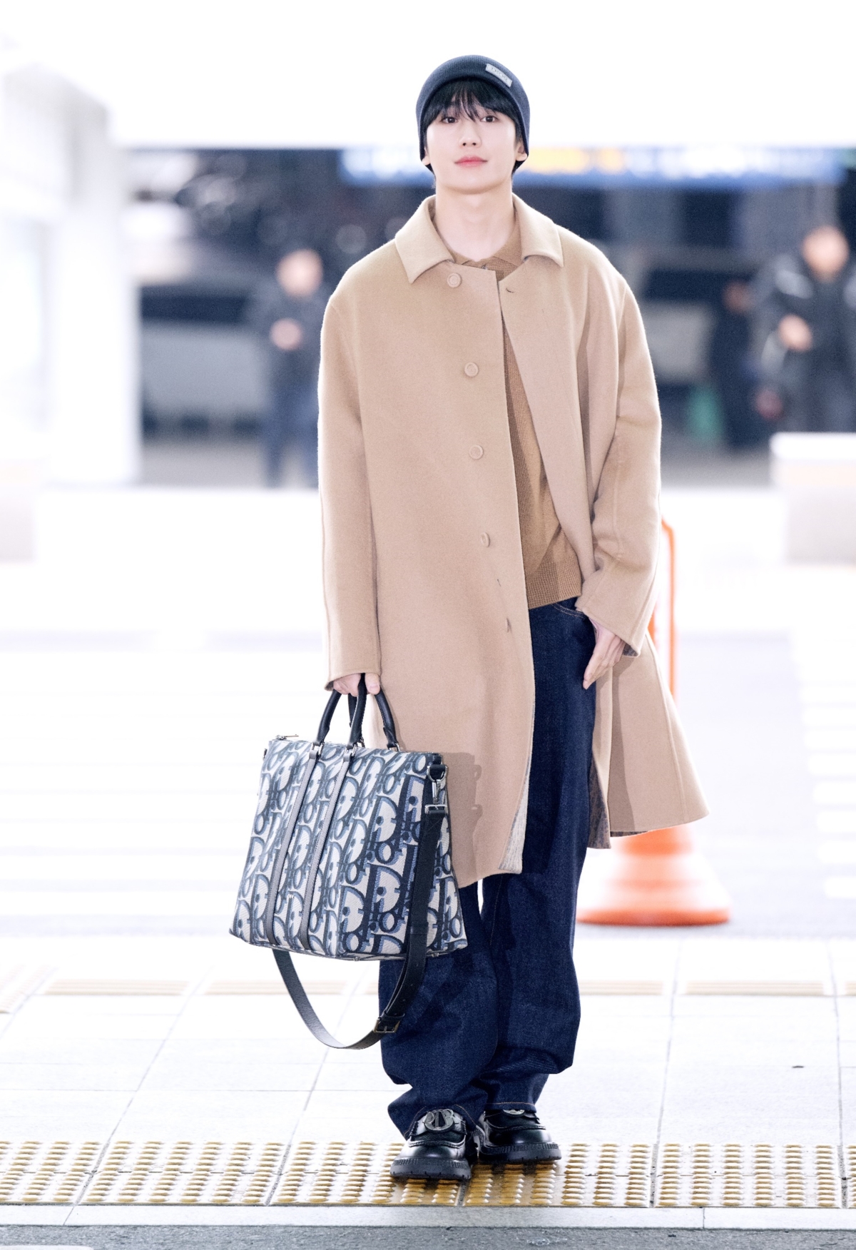 丁海寅身穿 Dior Icons 膠囊系列,手提著 Weekender 40 黑色大型 Dior Oblique 緹花手袋現身機場