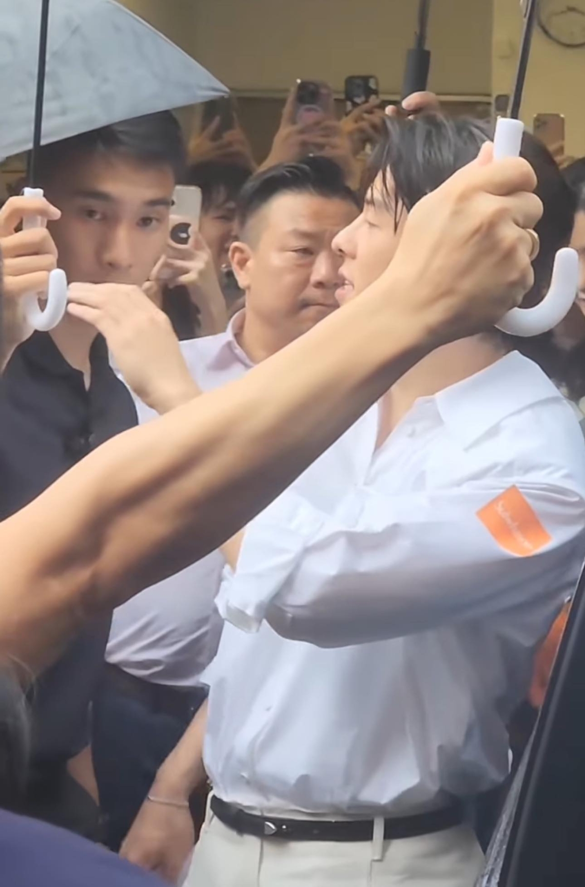 保鑣周宇晟替許光漢撐傘。