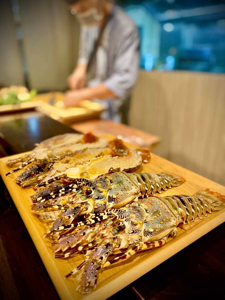 一排霸氣龍蝦平舖在料理檯前,新鮮看得見。