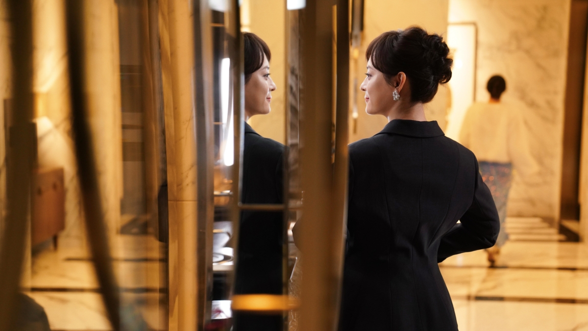 「胡曼黎」面對鏡子露出自信微笑。