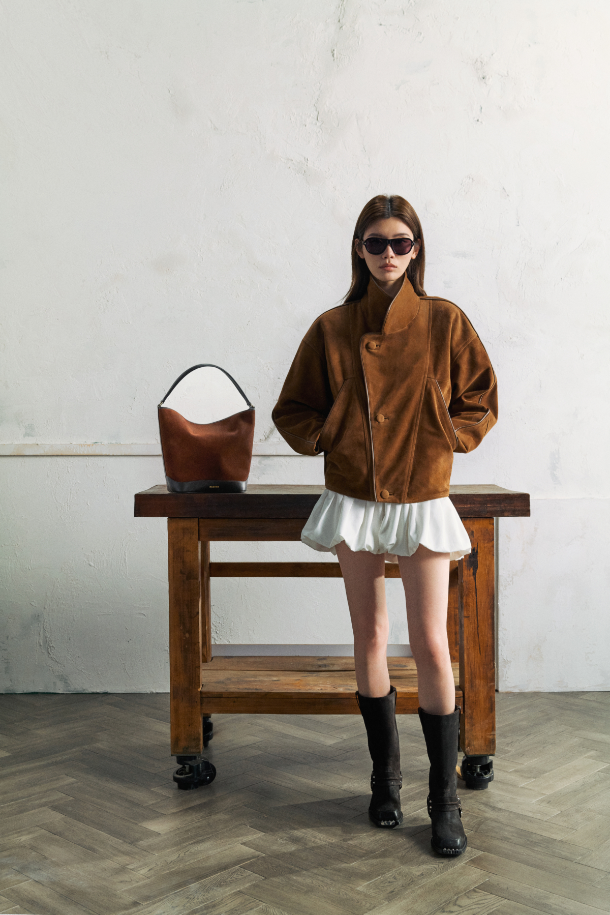 寬版麂皮外套搭配蓬鬆花苞裙，落肩設計與柔軟裙擺形成鮮明對比