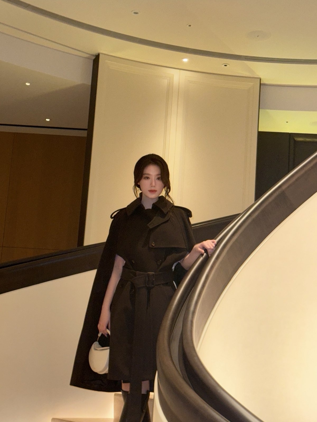 i-dle成員舒華穿著喀什米爾Belmont風衣披肩，設計融入風衣的經典元素包括肩章、槍墊與B字形帶扣腰帶，搭配秀款Bridle皂米色手拿包，舉手投足間充滿英倫女孩的優雅氣質。