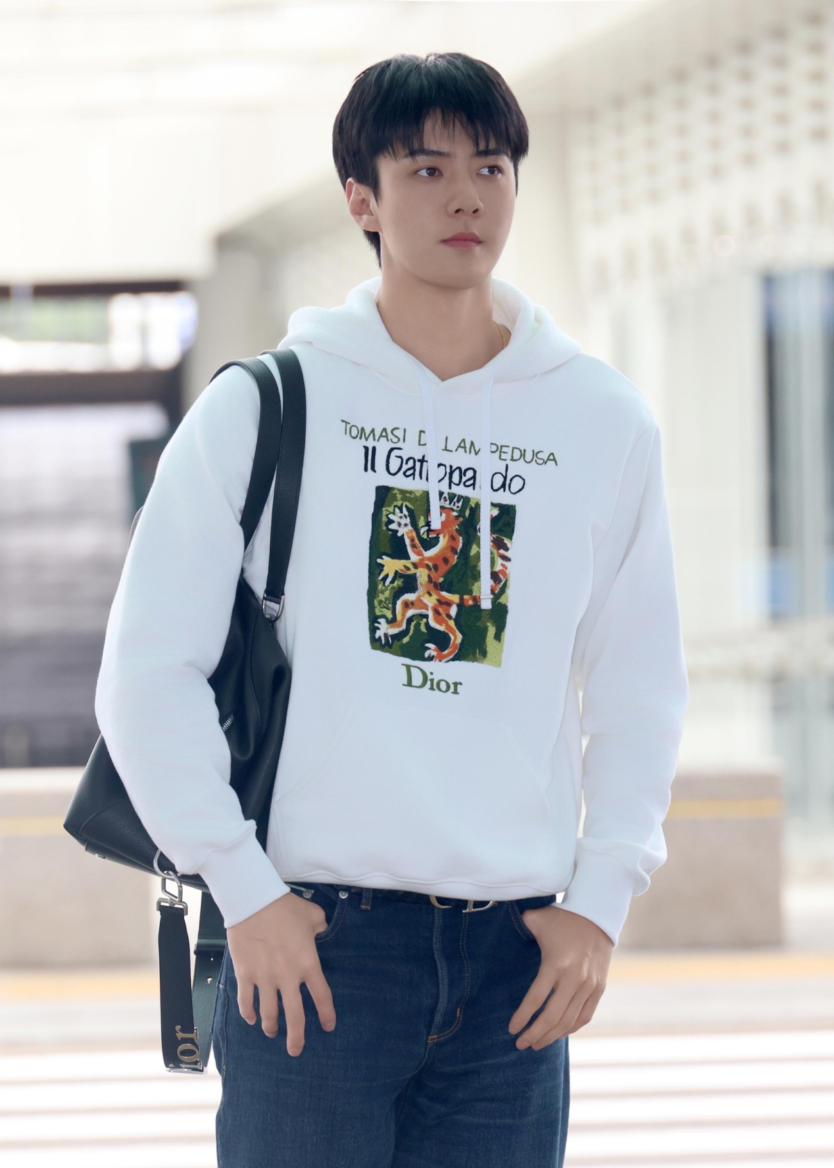 韓國男團EXO成員吳世勳SEHUN穿著Dior Book Cover連帽衫搭配Dior Bolt旅行包與Dior Hooper運動鞋出發前往 Dior 泰國Siam Paragon專賣店開幕活動