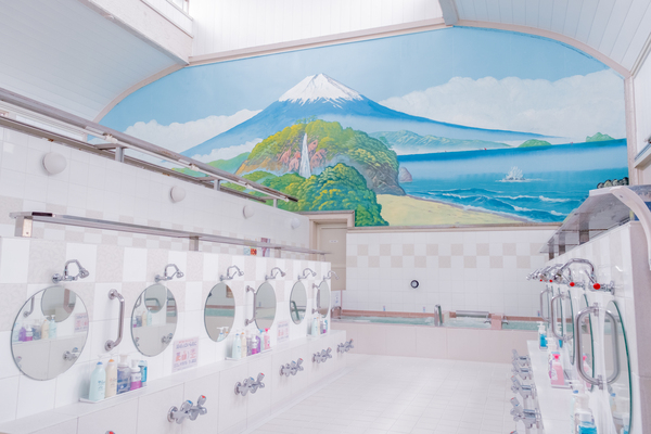 挑高的木造屋頂下，富士山壁畫靜靜映照著氤氳湯氣。